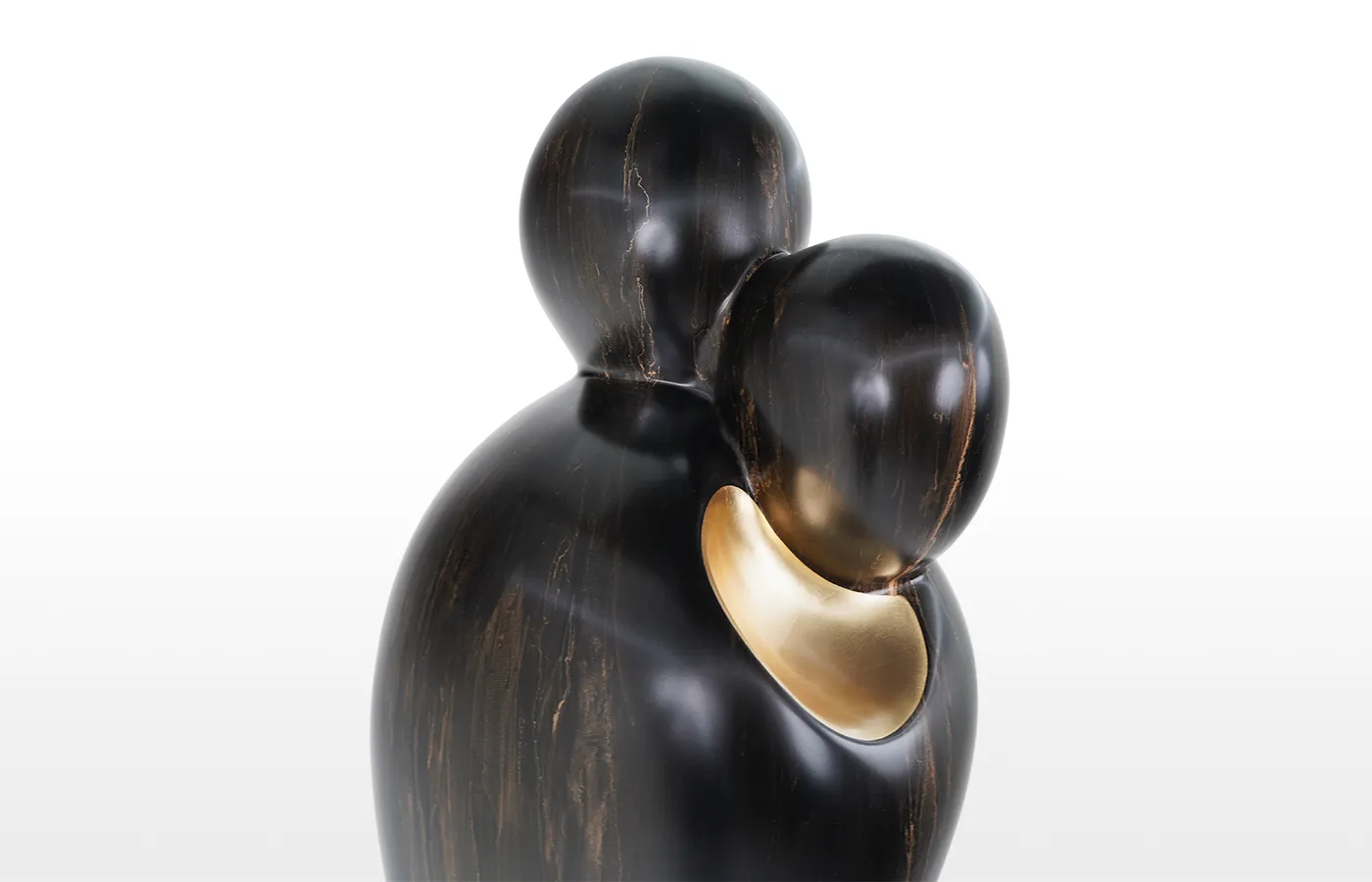 Close-up view of the sculpture Abraço in bronze and gold finish