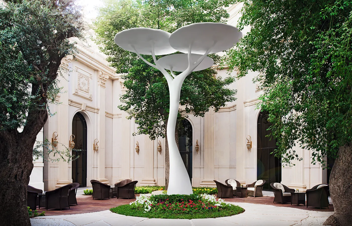 Jardim exterior em pedra com cadeirões e candeeiro escultural Acacia em acabamento branco ao centro