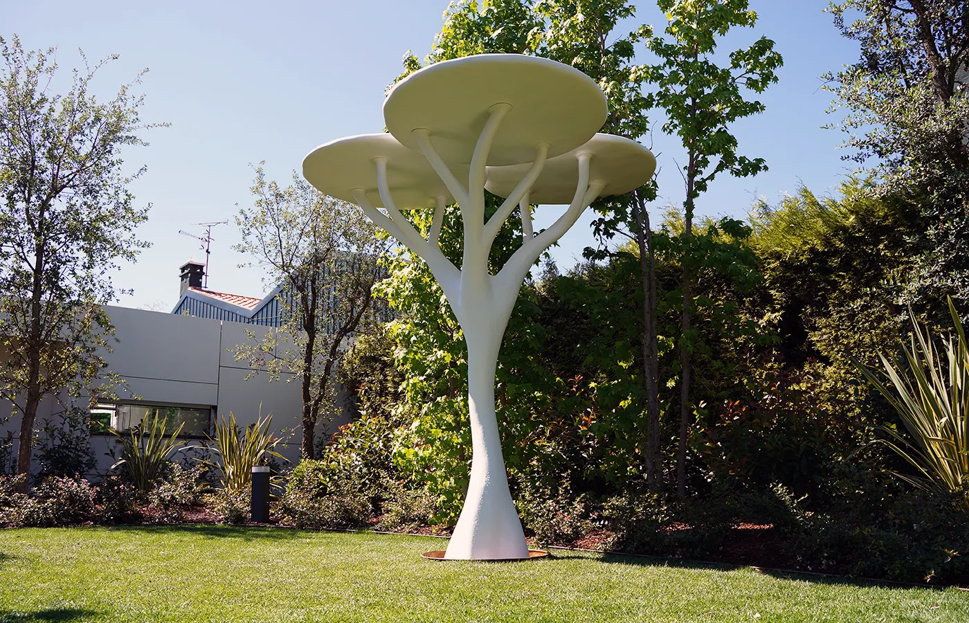Jardim exterior em relva com candeeiro escultural Acacia em acabamento branco