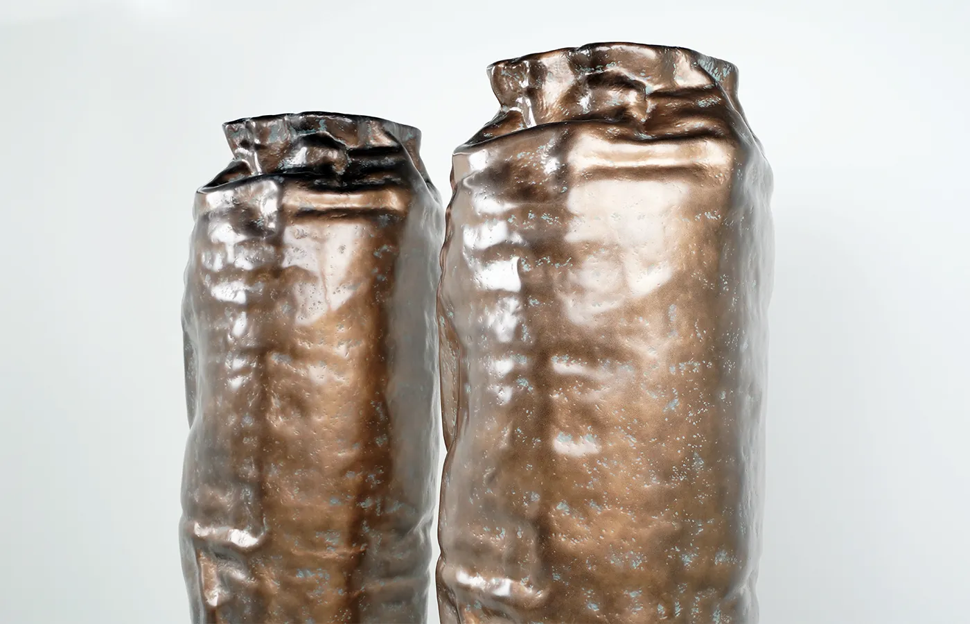 Close-up view with two Argus planters in a textured brass finish