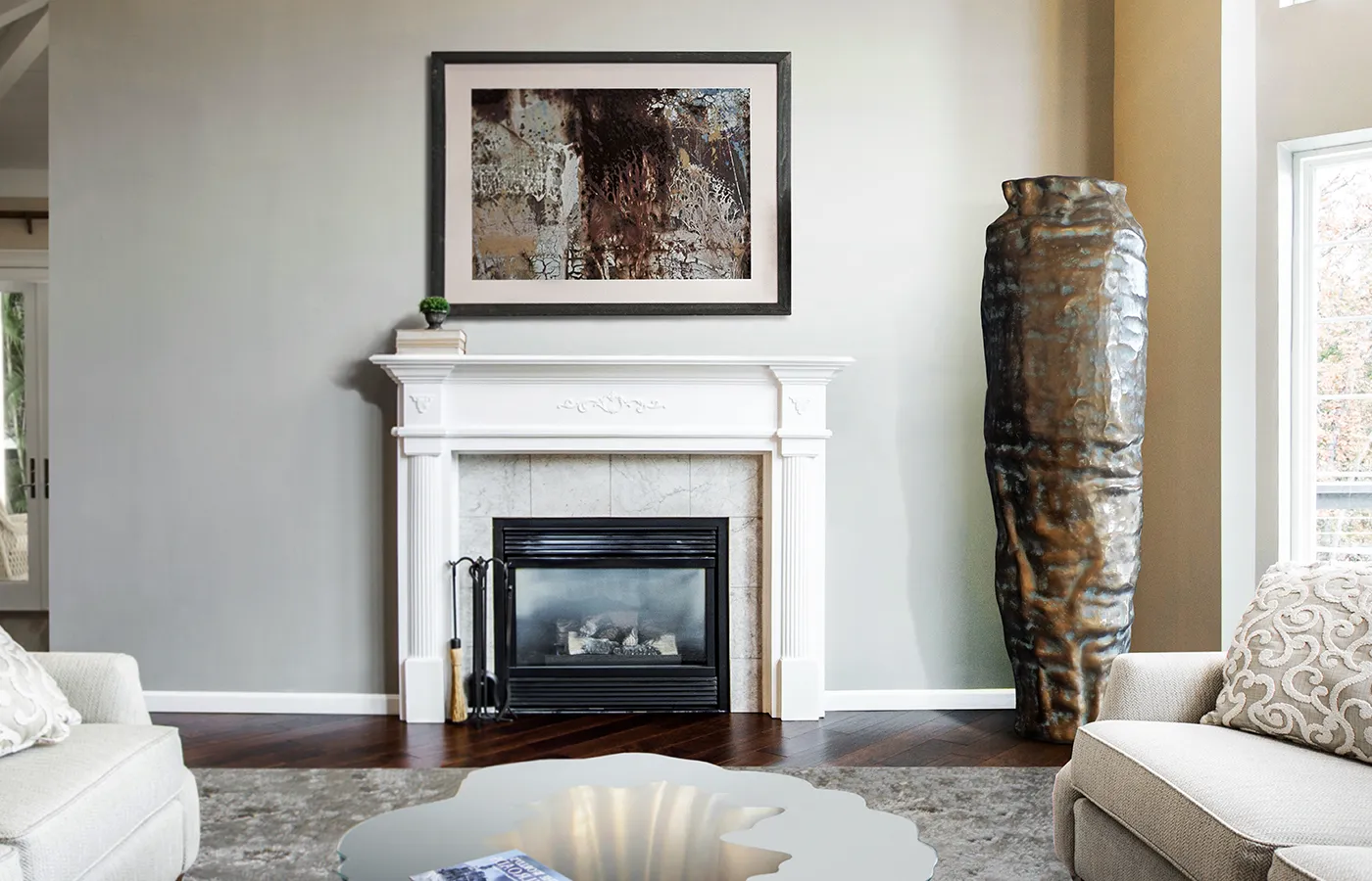 Ambiente de sala de estar com jarrão Argus em cor latão junto à janela