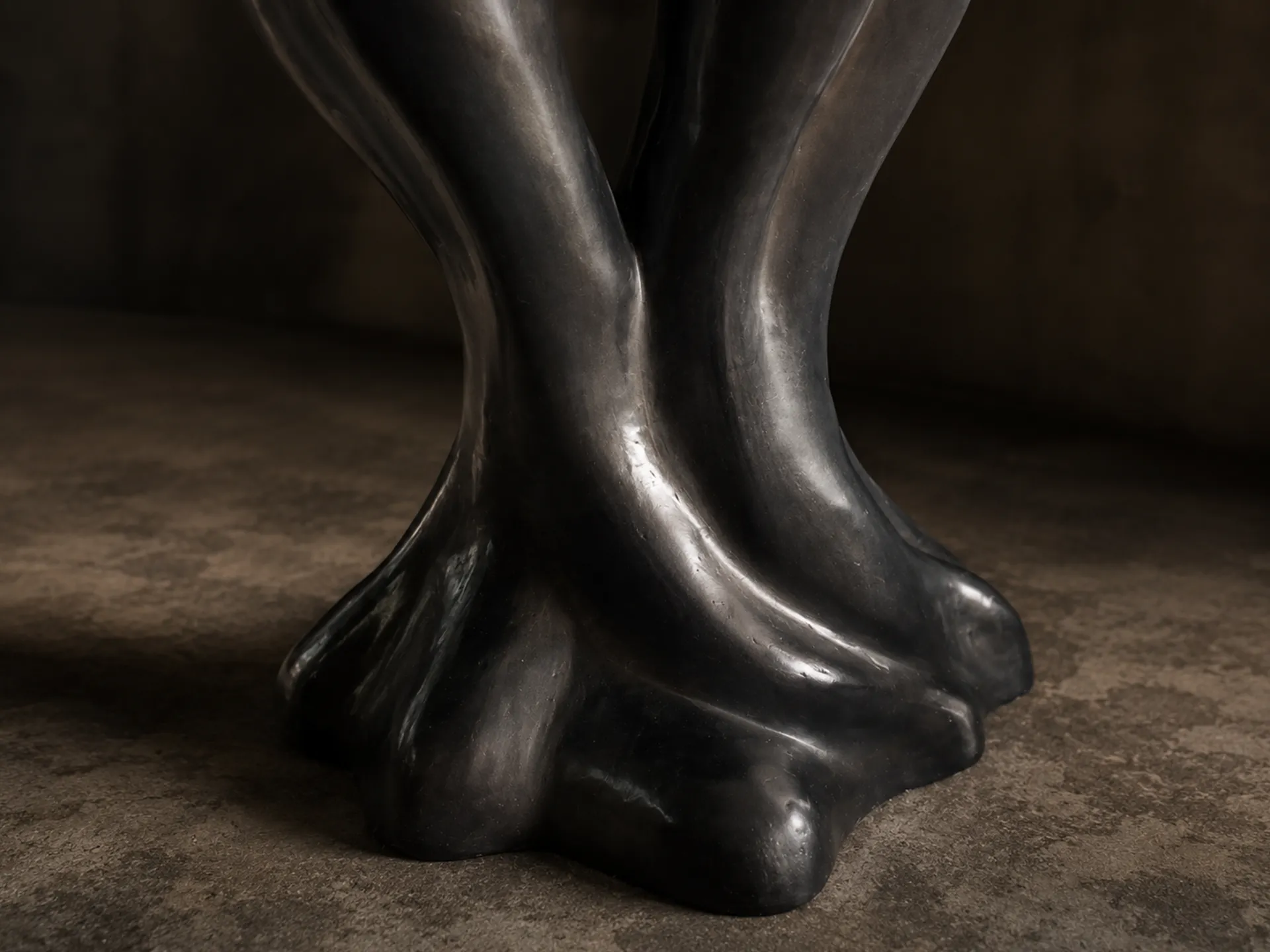Close-up detail showing the undulating, sculptural forms of the Athos table