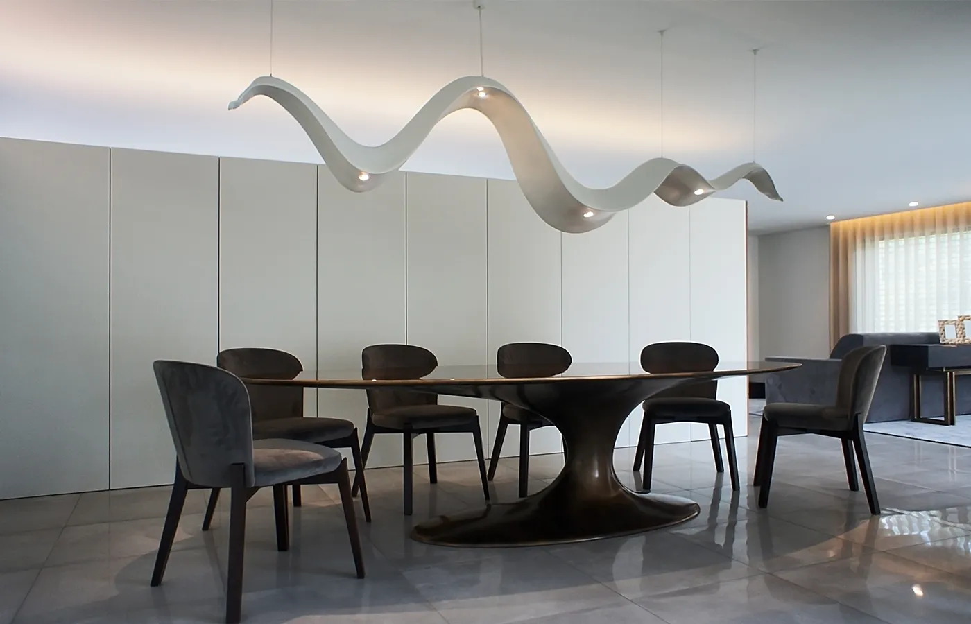 Ambiente de sala de jantar com candeeiro Aura em branco com uma mesa de jantar Jade oval e cadeiras estofadas