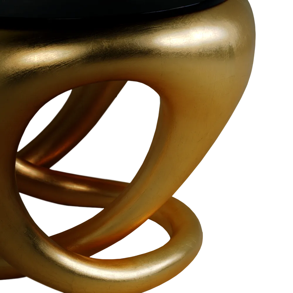 Vista em detalhe do corpo escultural da mesa de apoio Ballad em folha de ouro