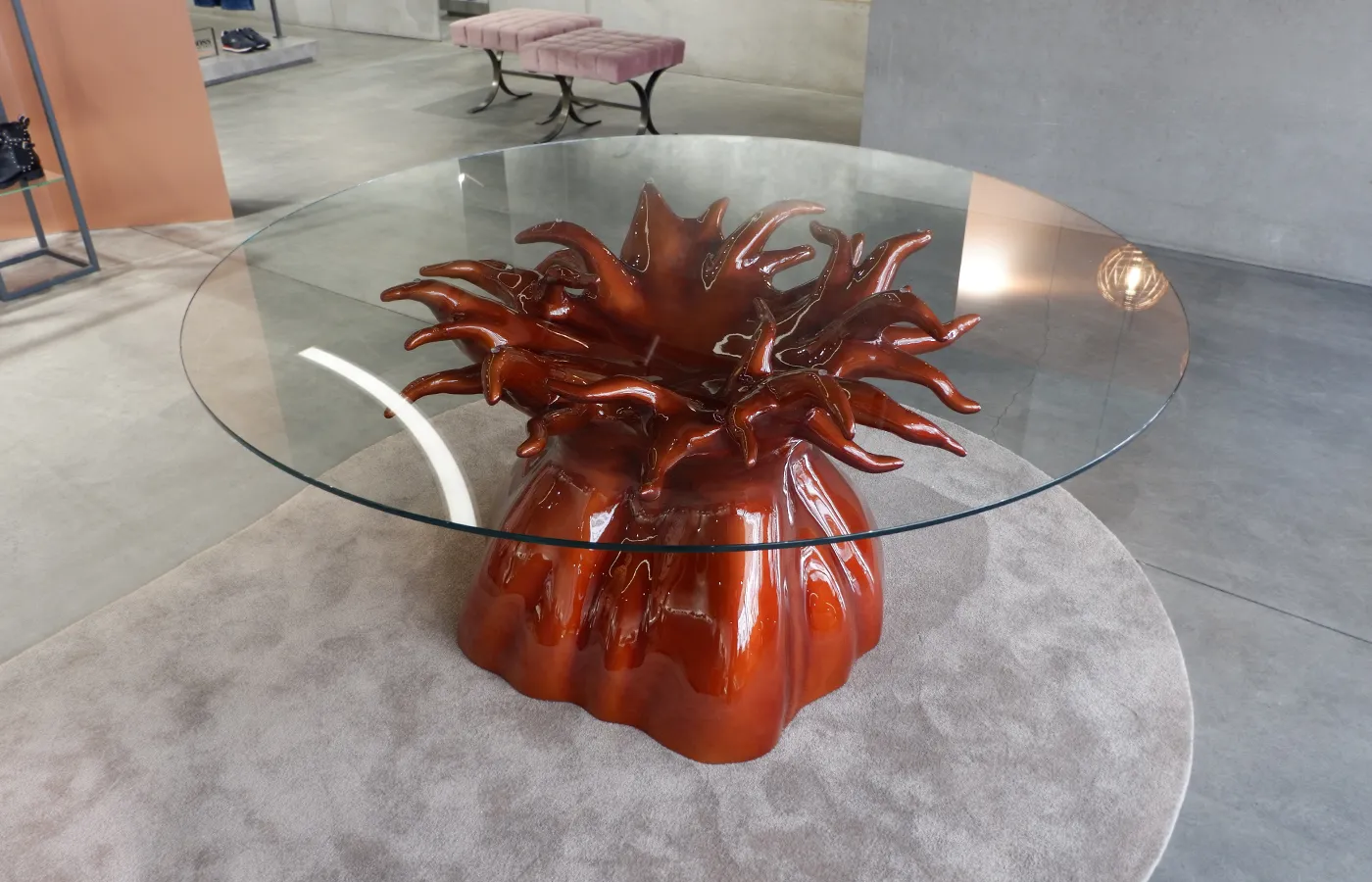Mesa de jantar Baobab em ambiente de loja com acabamento em tons vermelhos cromados