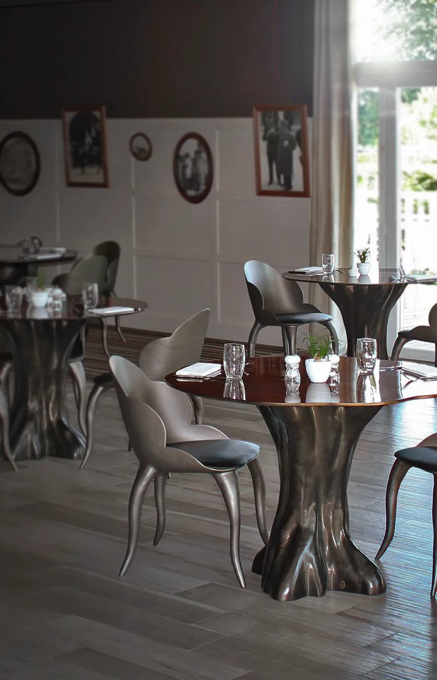 Calypso dining table set with walnut root top in a hotel restaurant setting