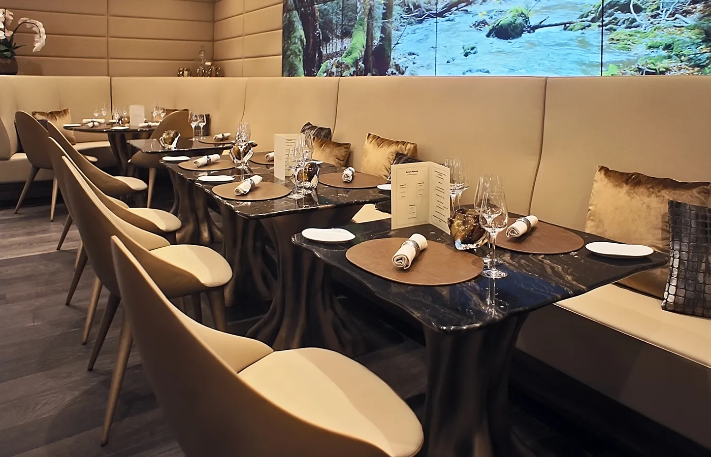 Calypso dining table set with black silk marble top in a restaurant setting