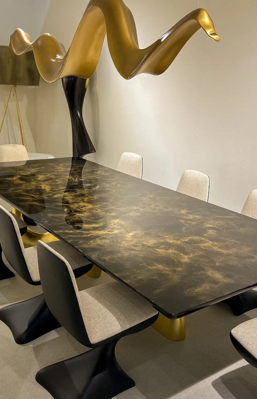 Exhibition setting with Cosmic dining table in gold leaf and artistic gold paint with Alyna chairs