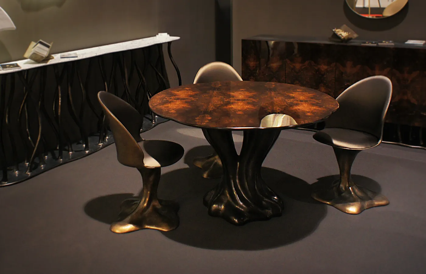 Ambiente de reunião em showroom com cadeiras Flora em cor bronze e mesa de jantar Athos