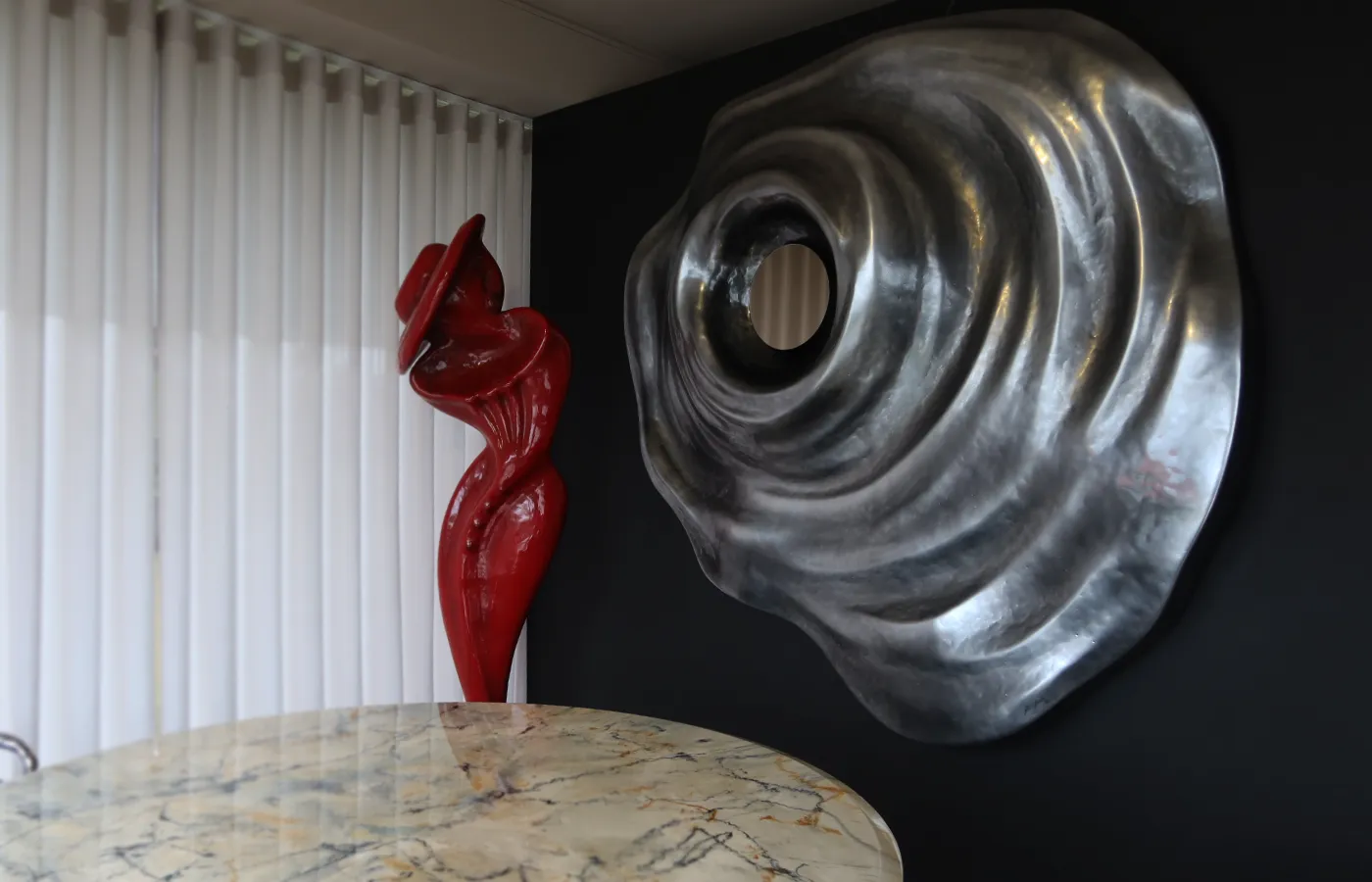 Sala de refeições com painel de parede Horus em cromado prata junto a escultura Musa