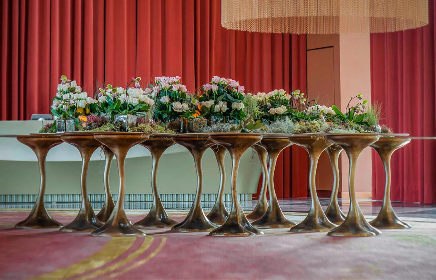 Hotel lobby with a composition of several Ivy dining tables in aged gold