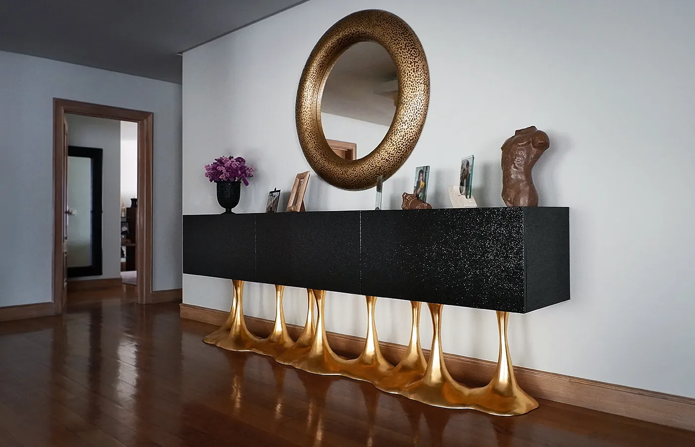 Hall de corredor com aparador Janus com caixa em preto texturado e base em folha de ouro