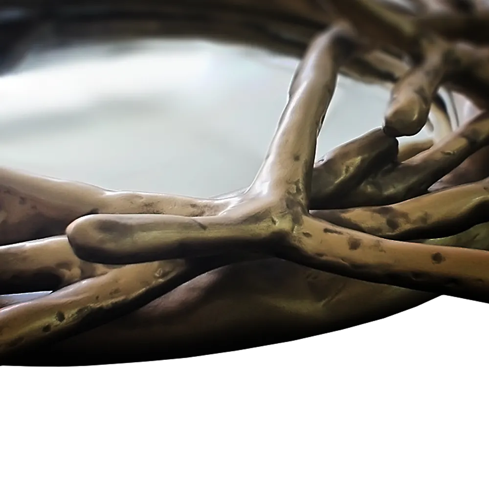 Vista em detalhe do espelho Nest com acabamento ouro envelhecido e destaque para a sua forma inspirada em raízes