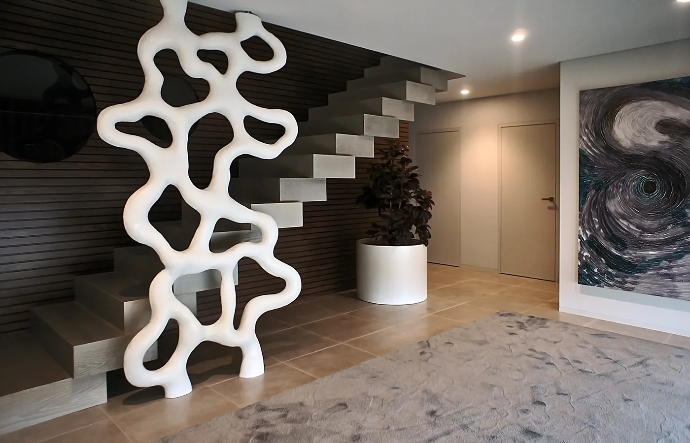 Hall de entrada com biombo Roots lacado a branco junto às escadas