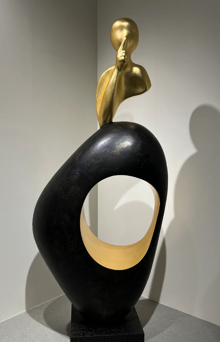 Canto de sala com escultura Silêncio em cor bronze texturado e folha de ouro