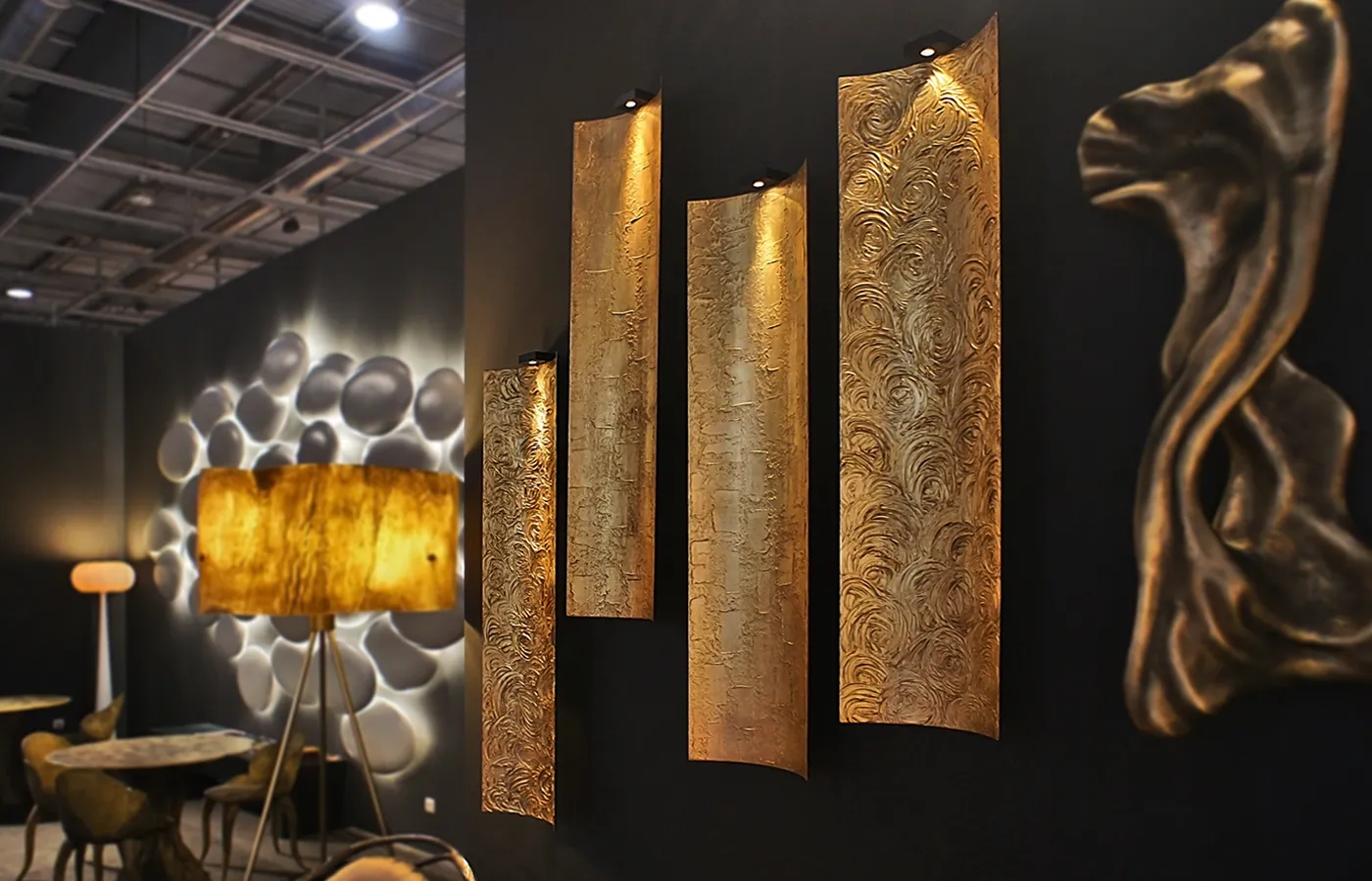 Conjunto de 4 painéis Tile em ambiente de showroom com várias peças Karpa, com acabamento em folha de ouro e texturados