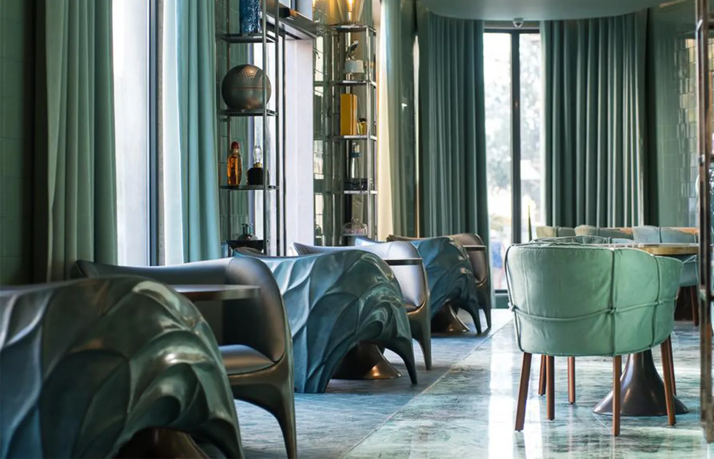 Sala de refeições de hotel com vários cadeirões Triton em acabamento azul turquesa