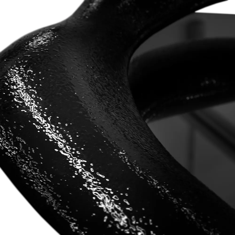 Close-up view of the large Twisted mirror, highlighting its high-gloss textured black finish