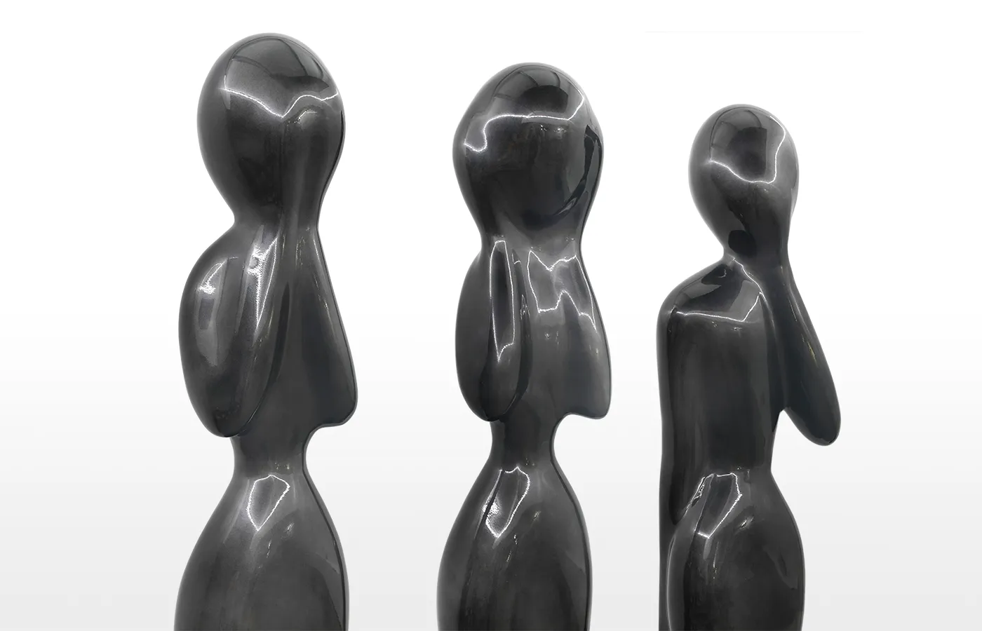 Close-up view of the Wisdom sculptures in lead-colored finish